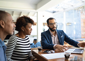 couple speaking with investor at laptop