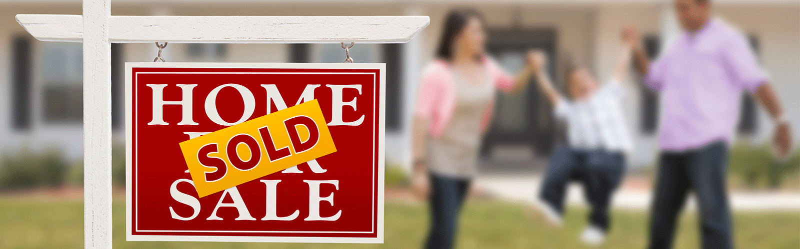 sold sign on a house with a family in the background