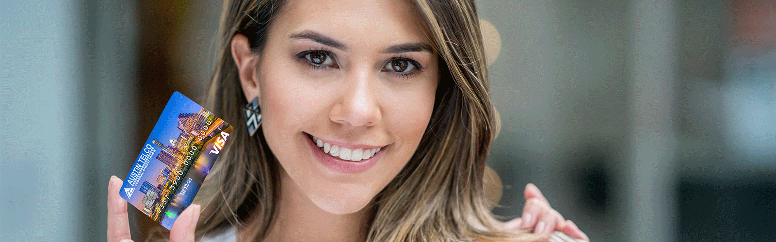 woman holding atfcu visa card and smiling