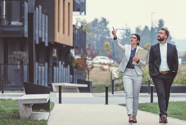 A business man and woman walking outside.