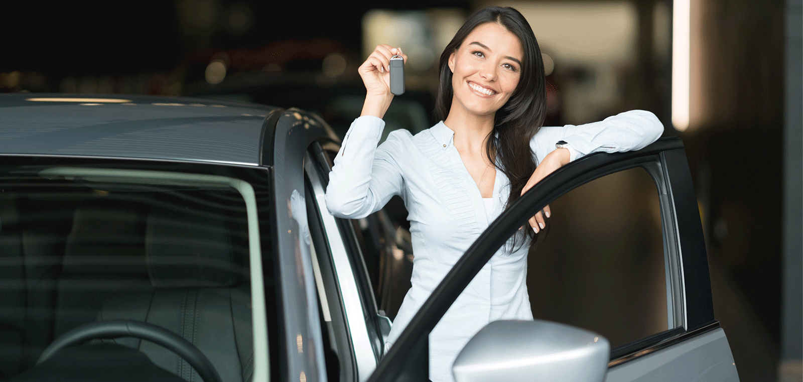 woman holding keys by car