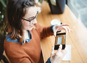 woman taking picture of check with her phone