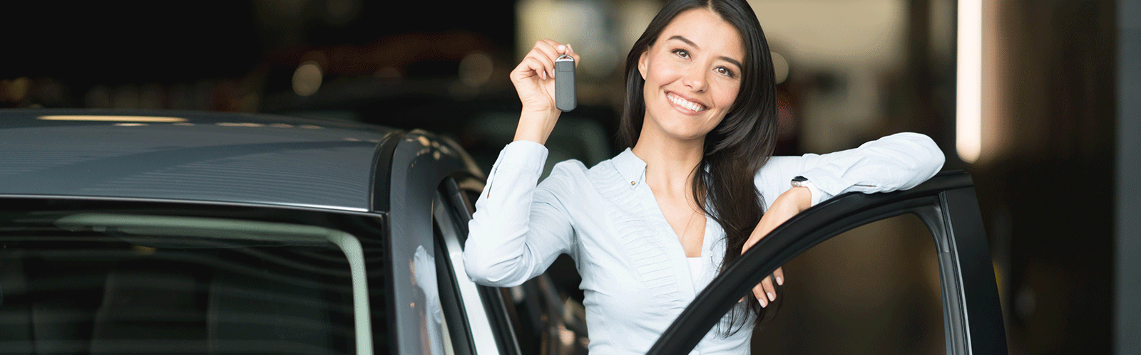 woman smiling while holding up keys
