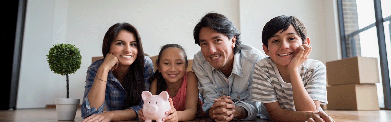 family on floor behind piggy bank and smiling