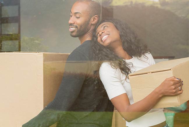 Couple carrying moving boxes.