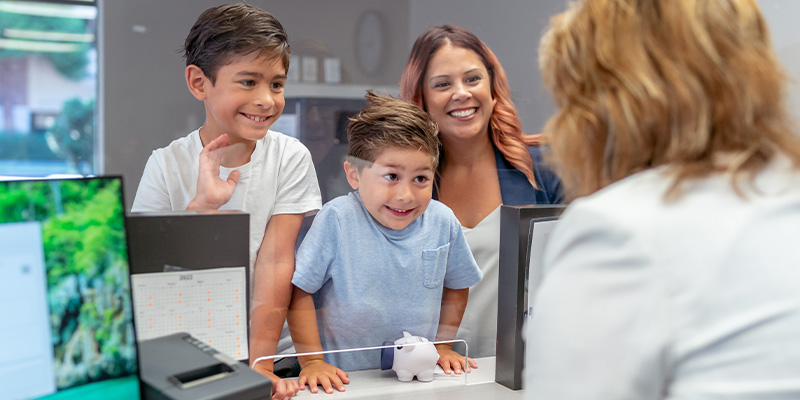 Family at a teller line in a credit union - ATFCU
